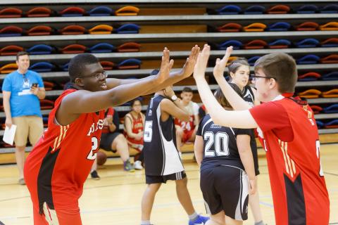 Athletes high five at a ASAA Unified sport event