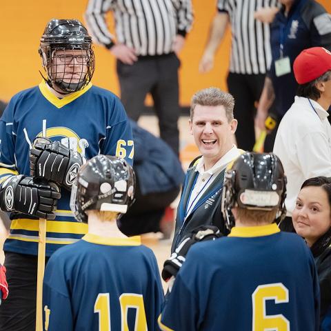 Randy James smiling in floor hockey team huddle