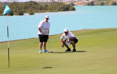 An athlete and caddie near a hole