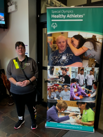 Stacey standing next to SOBC Healthy Athletes banner