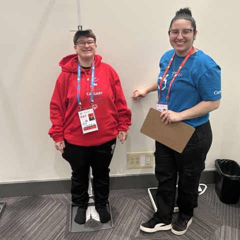 Jenna standing getting her height measured by health volunteer professional