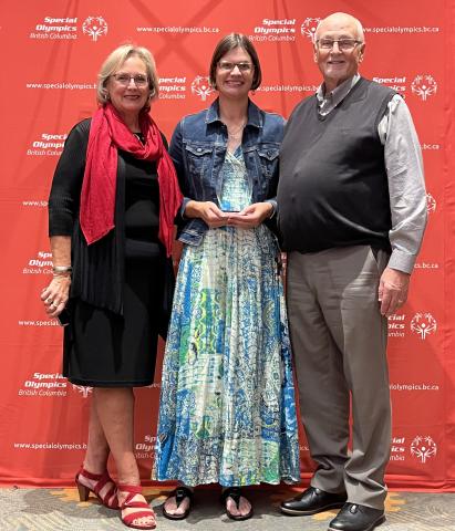 Kelsey Wyse holding award with family members