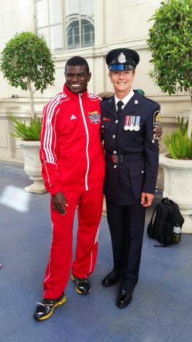 Inspector Joanne Wild, dressed in her police uniform poses for a photo with Special Olympics BC athlete Nigel.