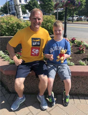 Braylon Hyggen sits with a Special Olympics Alberta athlete.