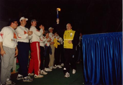 An old photo of Lorne White carrying the flame of hope in front of a crowd