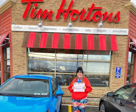 Athlete Megan Martin standing in front of a Tim Hortons, smiling