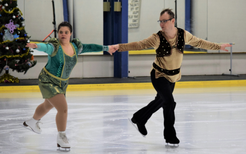 Nicole and David skate on the ice hand in hand.