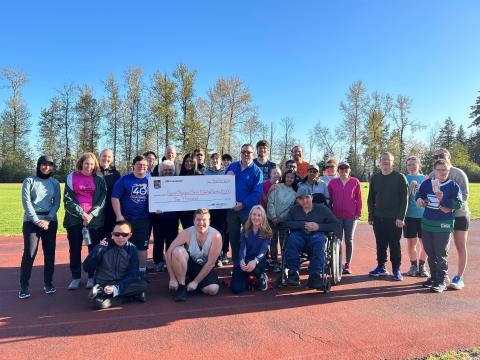 Group photo of SOBC Coquitlam athletes and coaches with RBC members holding a big cheque
