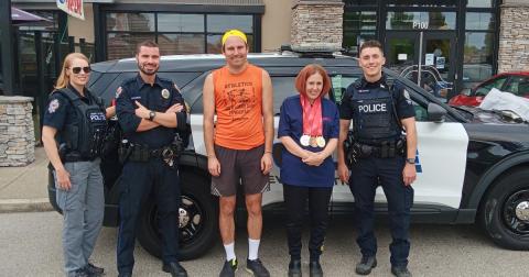 Group photo of SOBC athletes and law enforcement officers in front of Boston Pizza restaurant
