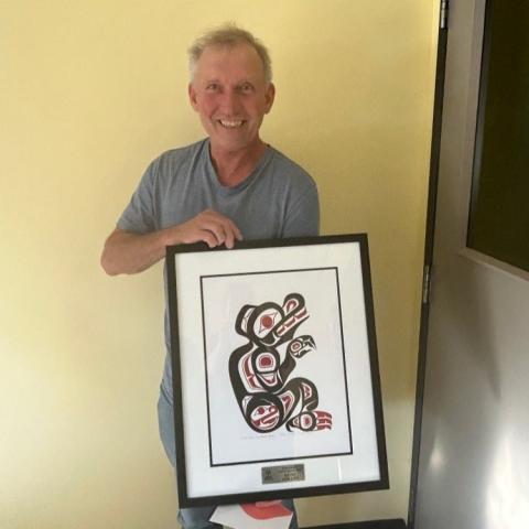 Kevin Phillips holding the plaque of the 2023 Grassroots Coach Award