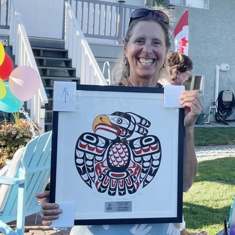 Annabel Stanley holding a framed print artwork