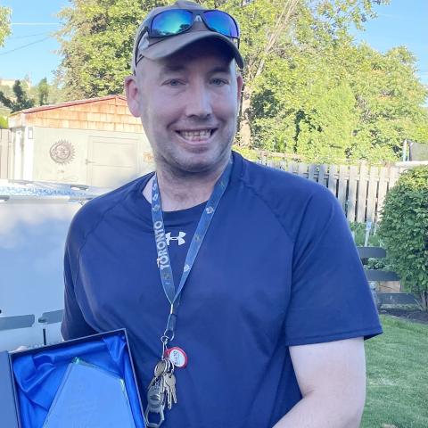 Chris holding his trophy and smiling