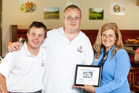 SOBC – Sunshine Coast athletes Gus Vaughn and Derrick Pye presenting a plaque to Tara Roden from the Blue Ocean Golf Club.