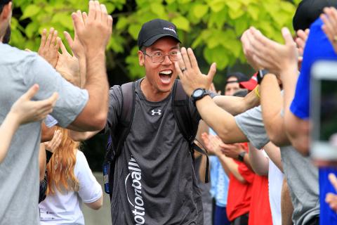 SOBC athlete high-fiving crowd with a big smile as he's running on to the field