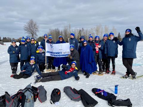 SO Team BC 2020 snowshoe team celebrating with snowshoe sign