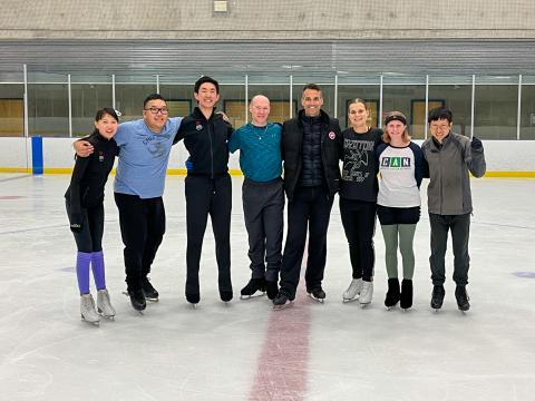 Figure skating athletes group photo with Ben Ferreira on the ice