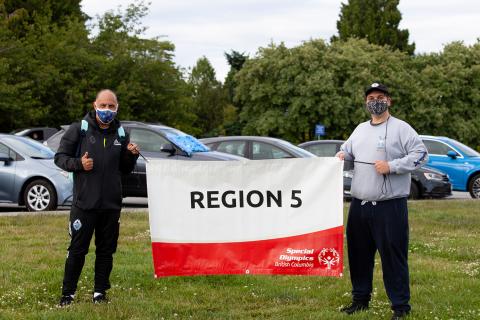 Carl Valentine and Daniel Thomas holding the Special Olympics BC Region 5 banner.