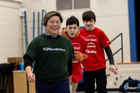 Phoebe smiling with two youth participants behind her and following her