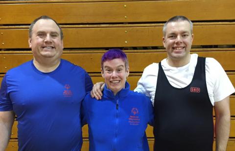 Jackie poses for a photo with two athletes he helps train