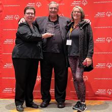 Clint Morrison holding award with family members