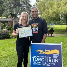 Lisa Bruschetta and Chief Del Manak holding LETR sign and artwork at greater Victoria Torch Run.