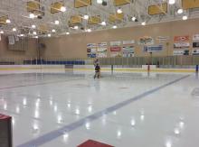 McArthur ice rink with hockey player talking to coach in the middle of the ice